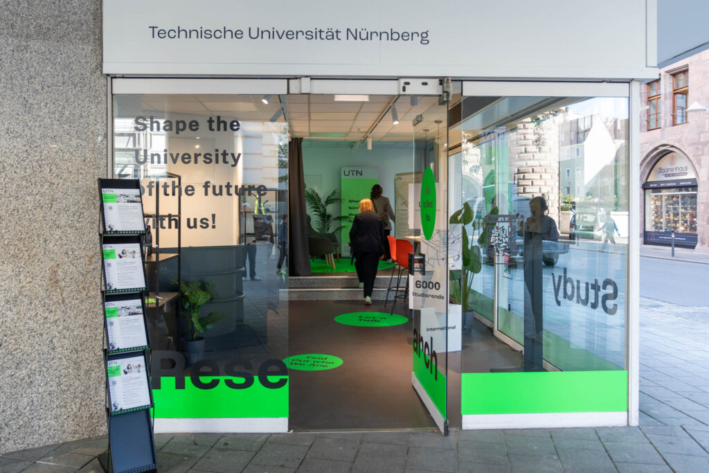 Der Eingang der UTN Science Lounge. Durch die Tür sind mehrere Personen zu sehen.