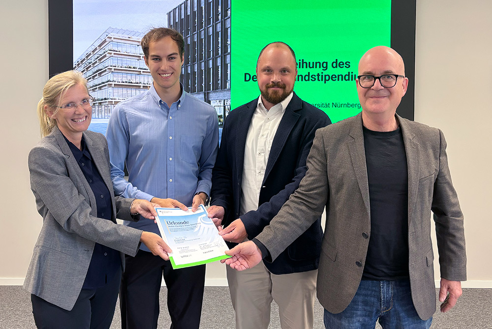 Gründungsvizepräsidentin Isa Jahnke überreicht gemeinsam mit Robin Sternberg, Dominik Renner von der TRATON Group und UTN-Präsident Prof. Dr. Michael Huth die Urkunde zum ersten Deutschlandstipendium der UTN